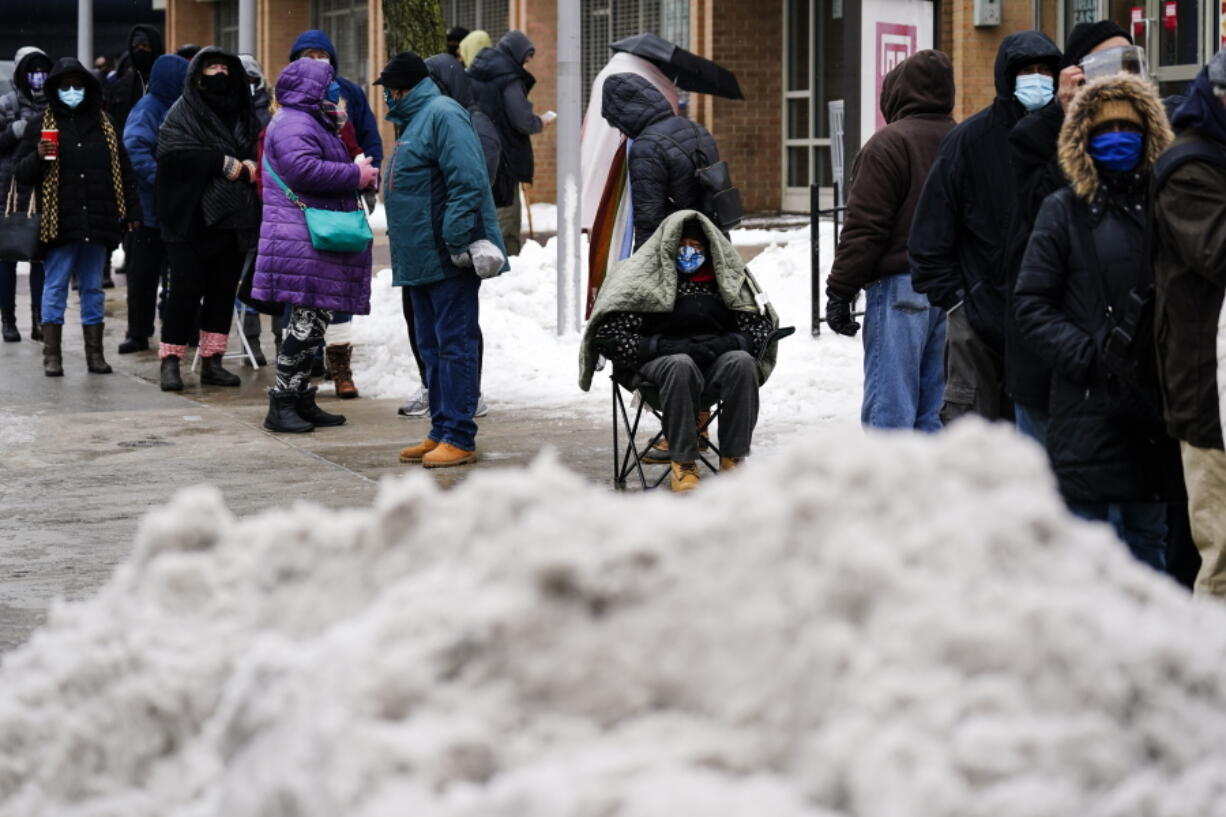 People wait in line for the opening of a 24-hour, walk-up COVID-19 vaccination clinic hosted by the Black Doctors COVID-19 Consortium at Temple University&#039;s Liacouras Center in Philadelphia, Friday, Feb. 19, 2021. Efforts to vaccinate Americans against COVID-19 have been stymied by a series of winter storms and outages in parts of the country not used to extreme cold weather, and hobbled transportation hubs and highways.