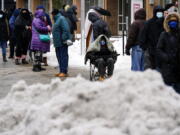 People wait in line for the opening of a 24-hour, walk-up COVID-19 vaccination clinic hosted by the Black Doctors COVID-19 Consortium at Temple University&#039;s Liacouras Center in Philadelphia, Friday, Feb. 19, 2021. Efforts to vaccinate Americans against COVID-19 have been stymied by a series of winter storms and outages in parts of the country not used to extreme cold weather, and hobbled transportation hubs and highways.