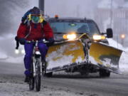 A bicyclist peddles on slick roads during a winter snow storm, Tuesday, Feb. 2, 2021, in Brunswick, Maine. (AP Photo/Robert F.