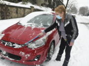 Charlene Dixon, of Pottsville, Pa., cleans snow off her car parked along Mahantongo Street in Pottsville, Pa., on Sunday morning, Feb. 7, 2021.