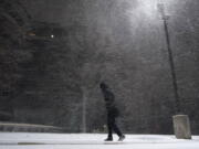 A woman walks through falling snow in San Antonio, Sunday, Feb. 14, 2021. Snow and ice blanketed large swaths of the U.S. on Sunday, prompting canceled flights, making driving perilous and reaching into areas as far south as Texas&#039; Gulf Coast, where snow and sleet were expected overnight.