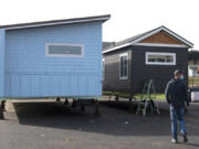 Derek Huegel walks toward two finished homes awaiting delivery on Thursday at the company&#039;s new 20,000-square-foot facility in Battle Ground. The company makes tiny, customizable homes that they build, deliver and install throughout the region.