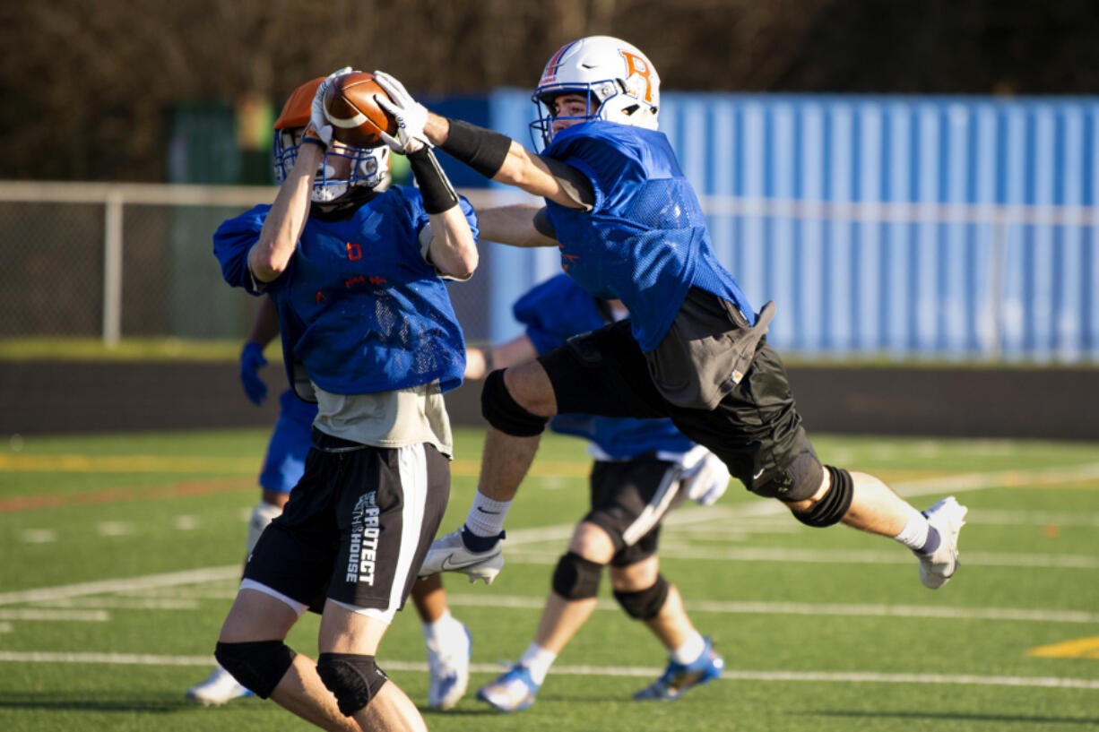 Ridgefield senior Tanner Roberts tries to swat away a pass attempt during a practice on Wednesday, March 3, 2021, at Ridgefield High School. Playing his fifth position in three years, Roberts continues to show his instincts and leadership are key to his football success.