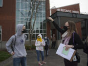 Junior John Graves, left, receives instructions on check-in procedures from Meaghan Thomson, Heritage&#039;s dean of students, on Thursday. Students and staff districtwide must fill out a COVID-screening questionnaire before being allowed into the building.