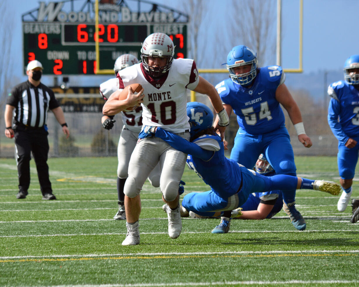 La Center's Jeremy Humphrey tries to bring down Montesano quarterback Trace Ridgway on Saturday at Woodland High School. Ridgway scored five touchdowns to lead the Bulldogs to a 41-24 victory against the Wildcats.