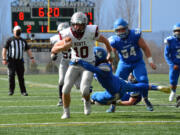 La Center's Jeremy Humphrey tries to bring down Montesano quarterback Trace Ridgway on Saturday at Woodland High School. Ridgway scored five touchdowns to lead the Bulldogs to a 41-24 victory against the Wildcats.