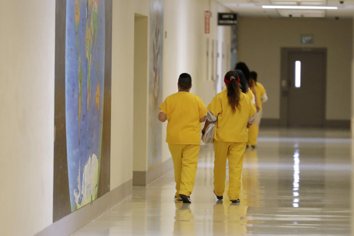 Detainees walk past a map of the world in a hallway of the U.S. Immigration and Customs Enforcement ICE detention facility Sept. 10, 2019 in Tacoma. The recent canceling of ICE contracts in Cowlitz County and at NORCOR in Oregon, along with a Washington state consideration of banning private prisons in the state, may severely hamper or even halt ICE detention and enforcement in the Pacific Northwest. (Ted S.