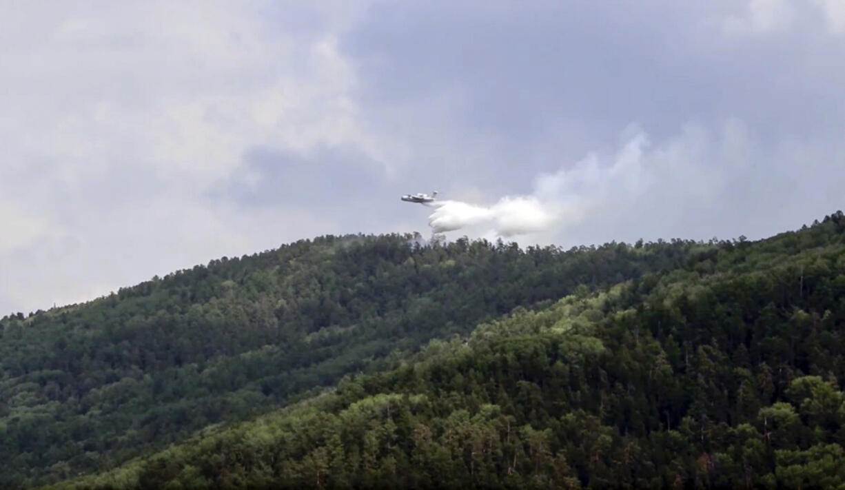 FILE - In this July 10, 2020, file image taken from video provided by Russian Emergency Ministry, a multipurpose amphibious aircraft releases water to extinguish a fire in the Trans-Baikal National Park in Buryatia, southern Siberia, Russia. The National Oceanic and Atmospheric AdministrationCfUs annual Arctic Report Card, released on Tuesday, Dec. 8, 2020, shows how warming temperatures in the Arctic are transforming the region&#039;s geography and ecosystems.