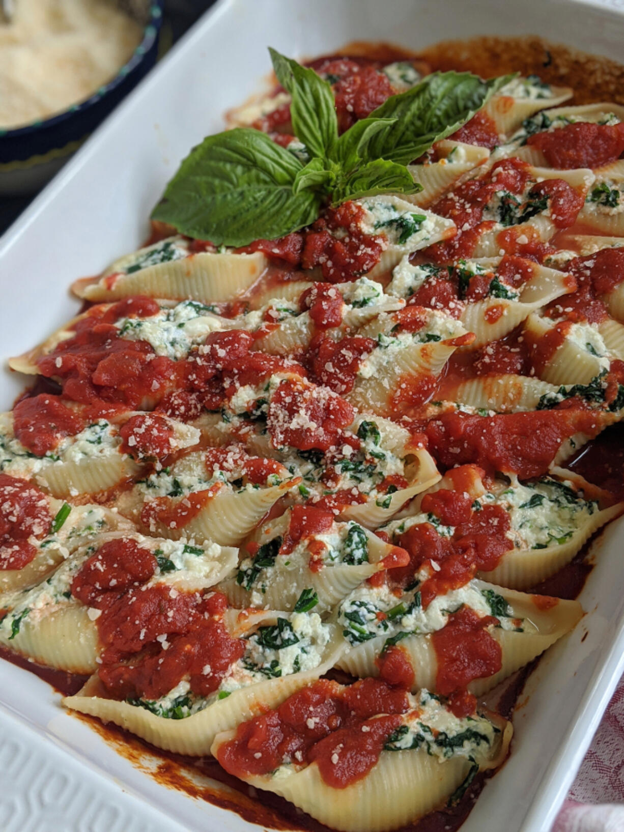 Jumbo shells stuffed with spinach and mozzarella and ricotta cheeses sit in a bed of marinara sauce.