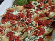 Jumbo shells stuffed with spinach and mozzarella and ricotta cheeses sit in a bed of marinara sauce.