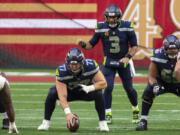 Seattle Seahawks center Ethan Pocic (77) prepares to snap the ball to quarterback Russell Wilson (3) during an NFL football game against the San Francisco 49ers, Sunday, Jan. 3, 2021, in Glendale, Ariz.