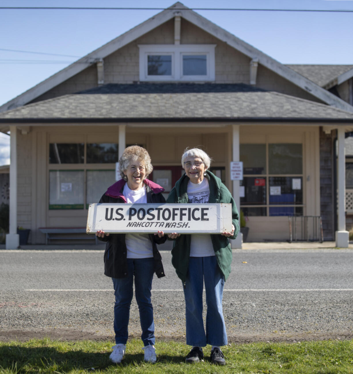 Postmasters Kathy Olson left and Gretchen Goodson holds the Nahcotta Post sign taken down from the building behind them that has been the Post Office for 132 years.  Nahcotta on the Long Beach peninsula population 125 lost its Post Office after USPS didn&#039;t renew its lease on the newly purchased property.