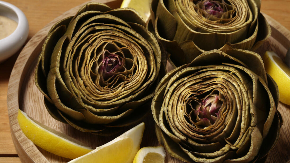 Artichokes steam in a lemon-scented bath until tender. (E.