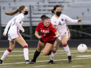 Camas sophomore Bella Burns fights through Union defenders Ashley Elcock, left, and Isabella Barrett in a 4A Greater St. Helens League girls soccer match on Friday, March 26, 2021, at Doc Harris Stadium. Camas won 2-0 to improve to 10-0 on the season.