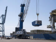 Crews unload a nacelle, the piece where the blades and turbine of a wind turbine meet, from a ship at the Port of Vancouver in March 2019. The port has sought to position itself as a major wind energy import destination in recent years.