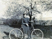 Matilda Stanger Overand shows off her bicycle. While machinists had adapted bicycles for women, clothing designers were farther behind. Although this model has a rear bumper to protect its rider from backsplashes, it lacks a chain guard and is a bit tall for its rider. This helps date the photo to the 1890s. Her father, John Stanger, was a Scotsman who arrived in the area with the Hudson&#039;s Bay Company in 1838.