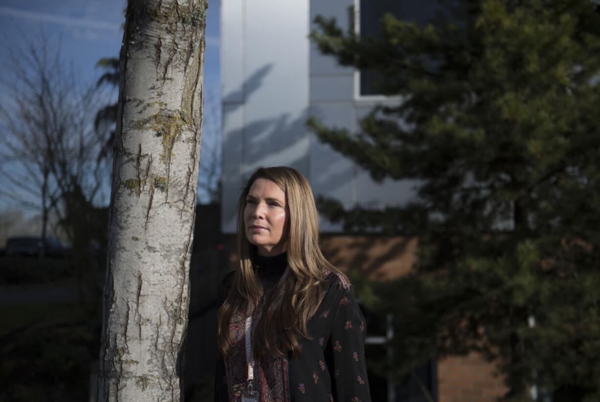 Melissa Pond, who works in COVID-19 response for Clark County Public Health, pauses for a portrait outside Public Health&#039;s building in Vancouver. Pond lost an uncle to the virus and also contracted it herself in the fall.