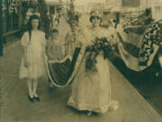 Reigning over the first Prune Festival in 1919, Prune Princess Fay Vance wore a white gown as her attendants, Josephine Dorrivan, Jane Parish Brown and Richard Kerchuye, hold her red cape. Clark County was at the time the Prune Capital of the World.