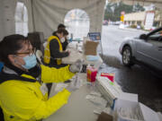 Volunteer pharmacist Serena Donnelly, left, prepares a dose of COVID-19 vaccine while working behind-the-scenes at the new large-scale vaccination site at Tower Mall on Friday morning, March 5, 2021. The vaccinations are by appointment only.