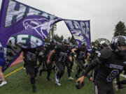 Heritage football players wear face masks as they charge onto the field to play the second half at McKenzie Stadium on Friday afternoon, March 5, 2021.