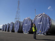 Katie Odem, marketing communications manager for the Port of Vancouver, looks over wind turbine towers that are currently being stored at the port and are waiting to be shipped out by truck. A record-breaking year of wind component imports helped the port during an otherwise challenging 2020 due to the COVID-19 pandemic.