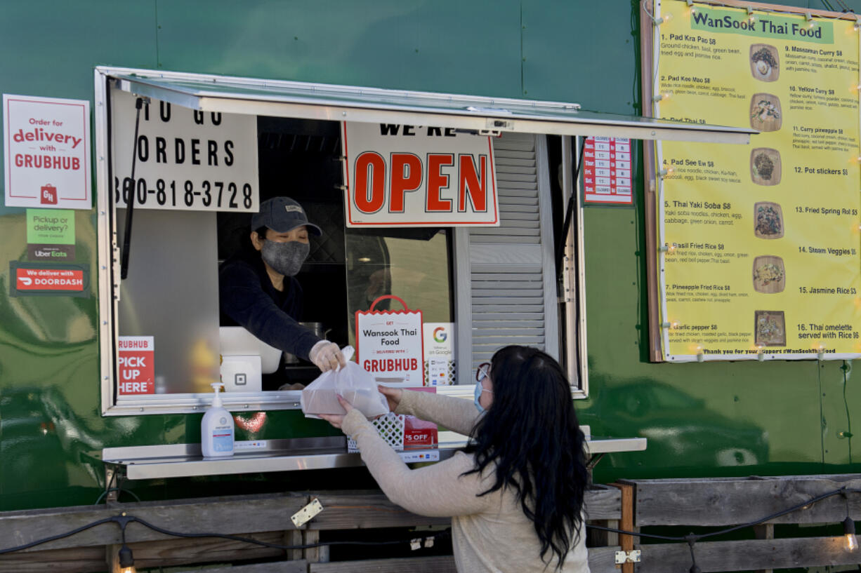 Cashier Amber Ounaphom of WanSook Thai Food, left, hands an order to customer Cearah Hiatt of Vancouver. New restaurants like WanSook are able to start from scratch and build a business model up, they said, and having a food cart makes fewer worries than brick-and-mortar indoor spots.&quot;It&#039;s easier, smaller and has less overhead,&quot; co-owner David Hardin said.