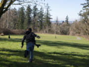 Pete Knight tosses his disc on the 15th hole of the site of the new Hartwood Park disc golf course on Thursday in Washougal.