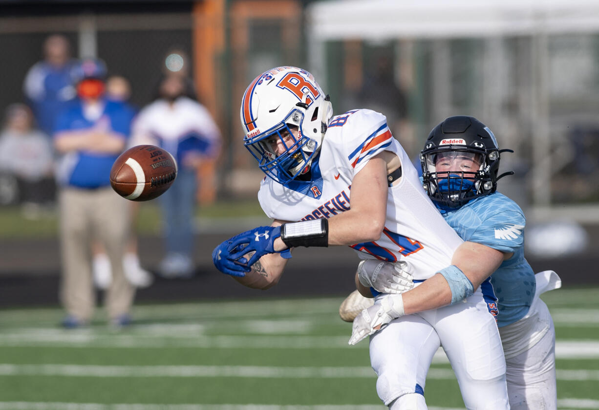 Ridgefield’s Aidan Hunt can’t corral a fourth-quarter pass as Hockinson’s Adam Nute deflects it away on Saturday, March 13, 2021, at District Stadium in Battle Ground. Hockinson won 14-7 in the game between the 2A Greater St. Helens League’s top two teams.