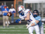 Ridgefield’s Aidan Hunt can’t corral a fourth-quarter pass as Hockinson’s Adam Nute deflects it away on Saturday, March 13, 2021, at District Stadium in Battle Ground. Hockinson won 14-7 in the game between the 2A Greater St. Helens League’s top two teams.