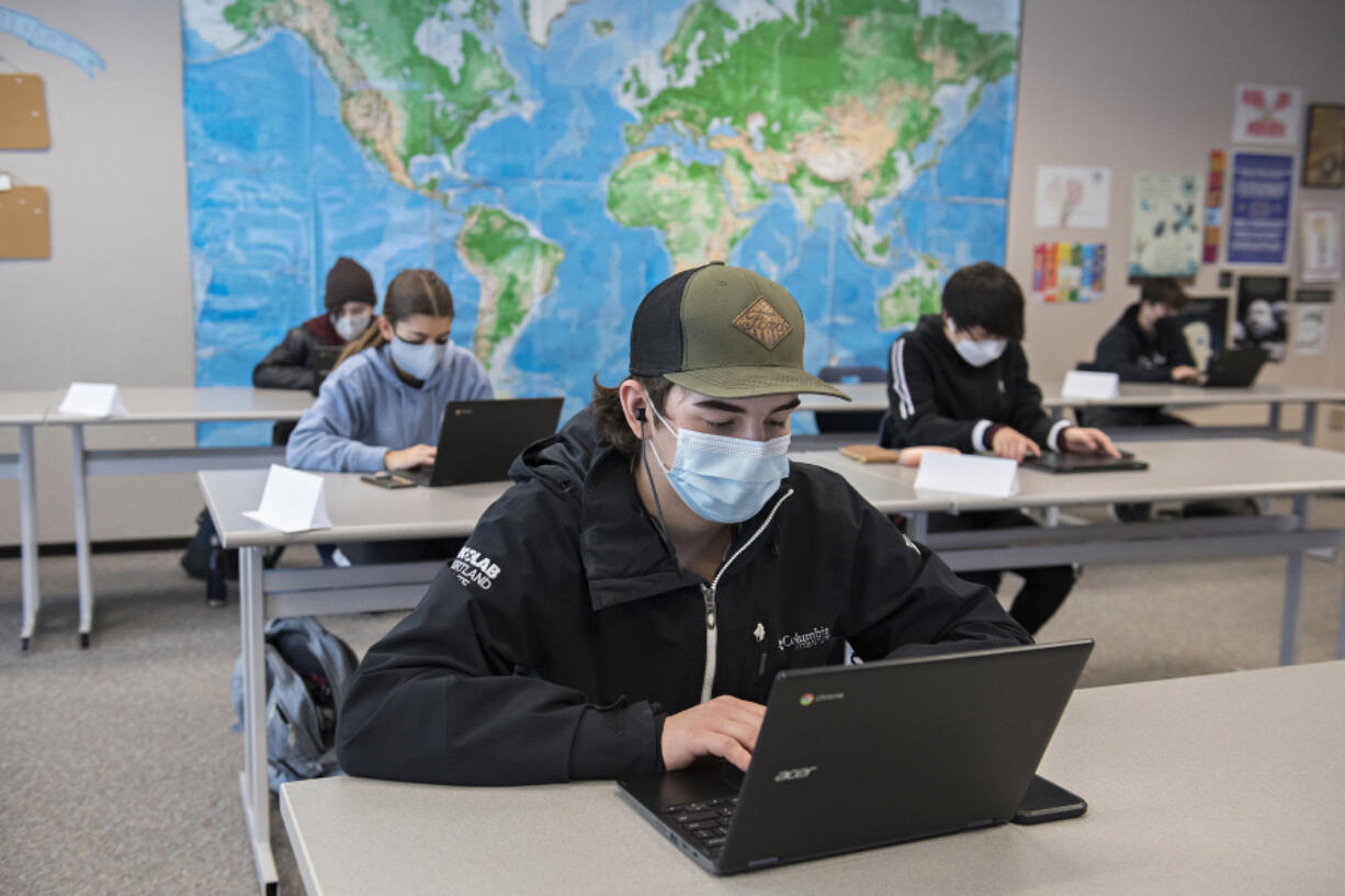 Skyview High School sophomore Joe Watson, 16, center, joins classmates during English class on Monday. Vancouver Public Schools welcomed high school students across all grades into hybrid learning. It&#039;s their first day back in the classroom since schools shut down March 13, 2020.