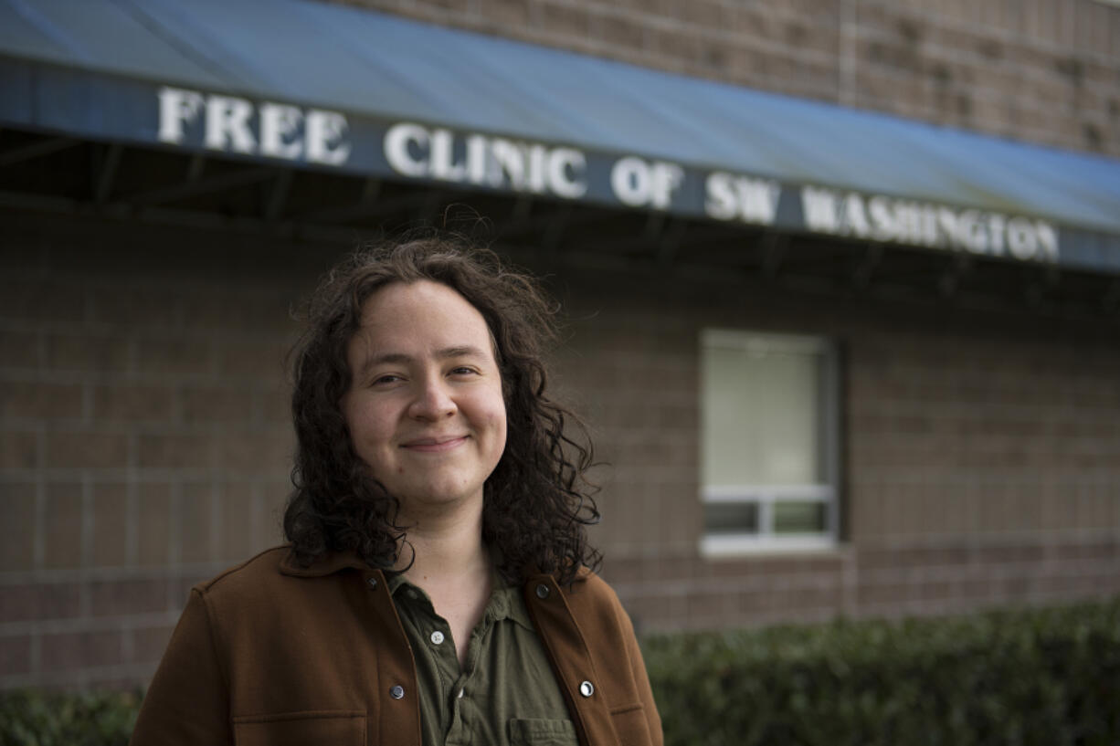 Daniel Salazar Mollinedo, patient care coordinator at the Free Clinic of Southwest Washington, walks through the front door of the building after putting his mask on.