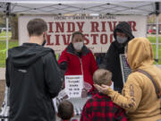 Jocelyn and William Stauffer of Washougal&#039;s Windy River Livestock sell pepperoni sticks to a family on Saturday, opening day for the Vancouver Farmers Market&#039;s 32nd season. Windy River launched years ago as a sideline for the Stauffers, but business has picked up tremendously during the pandemic, they said.