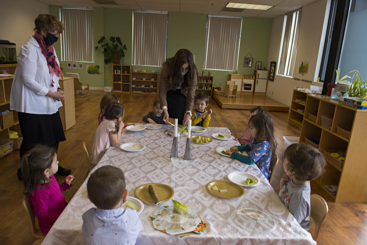 Tzivie Greenberg, center in brown jacket, director of Chabad Jewish Center, joins preschoolers as they learn more about Passover and the Seder plate on Friday morning, March 26, 2021. The Seder plate is eaten on Saturday night at the beginning of Passover, which is an eight-day Jewish holiday.