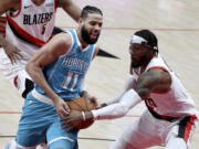 Portland Trail Blazers forward Robert Covington, right, grabs the ball away from Charlotte Hornets forward Cody Martin, left, during the first half of an NBA basketball game in Portland, Ore., Monday, March 1, 2021.