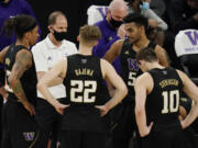 Washington head coach Mike Hopkins speaks with his players during the second half of an NCAA college basketball game in the first round of the Pac-12 men's tournament Wednesday, March 10, 2021, in Las Vegas.