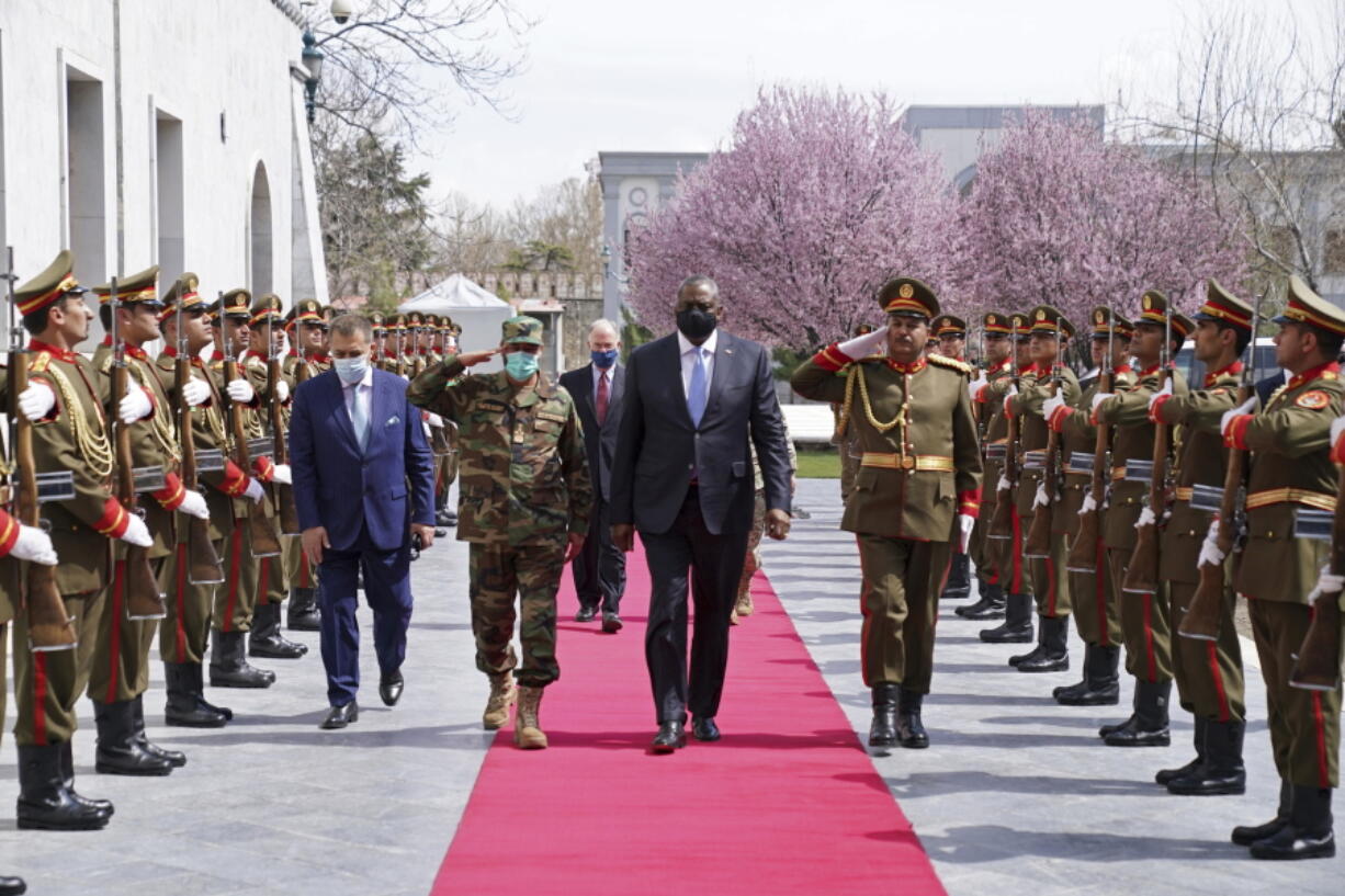 ADDS REFERENCE TO ACTING AFGHAN MINISTER OF DEFENSE YASIN ZIA - U.S. Defense Secretary Lloyd Austin, center, walks on the red carpet with Acting Afghan Minister of Defense Yasin Zia as they review an honor guard at the presidential palace in Kabul, Afghanistan, Sunday, March 21, 2021. Austin arrived in Kabul on his first trip to Afghanistan as Pentagon chief, amid swirling questions about how long American troops will remain in the country.