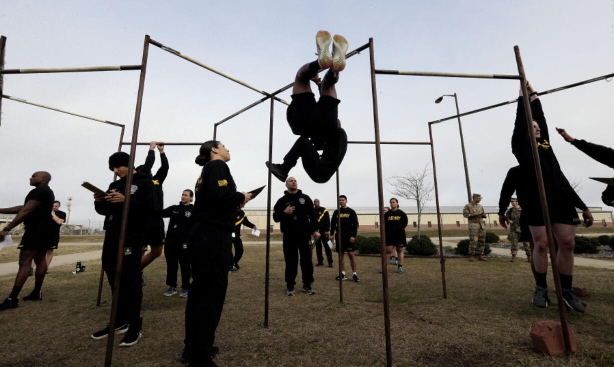 FILE - In this Jan. 8, 2019, file photo, U.S Army troops training to serve as instructors participate in the new Army combat fitness test at the 108th Air Defense Artillery Brigade compound at Fort Bragg, N.C. Army leaders are kicking out the requirement that soldiers do at least one leg tuck as part of the new physical fitness test, after finding many troops - particularly women - were unable to do the exercise that requires them to raise their knees while hanging from a bar.