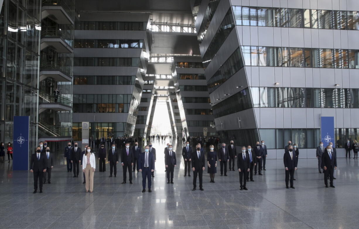 NATO foreign ministers wear protective masks as pose for a socially distanced group photo during a meeting of NATO foreign ministers at NATO headquarters in Brussels, Tuesday, March 23, 2021.