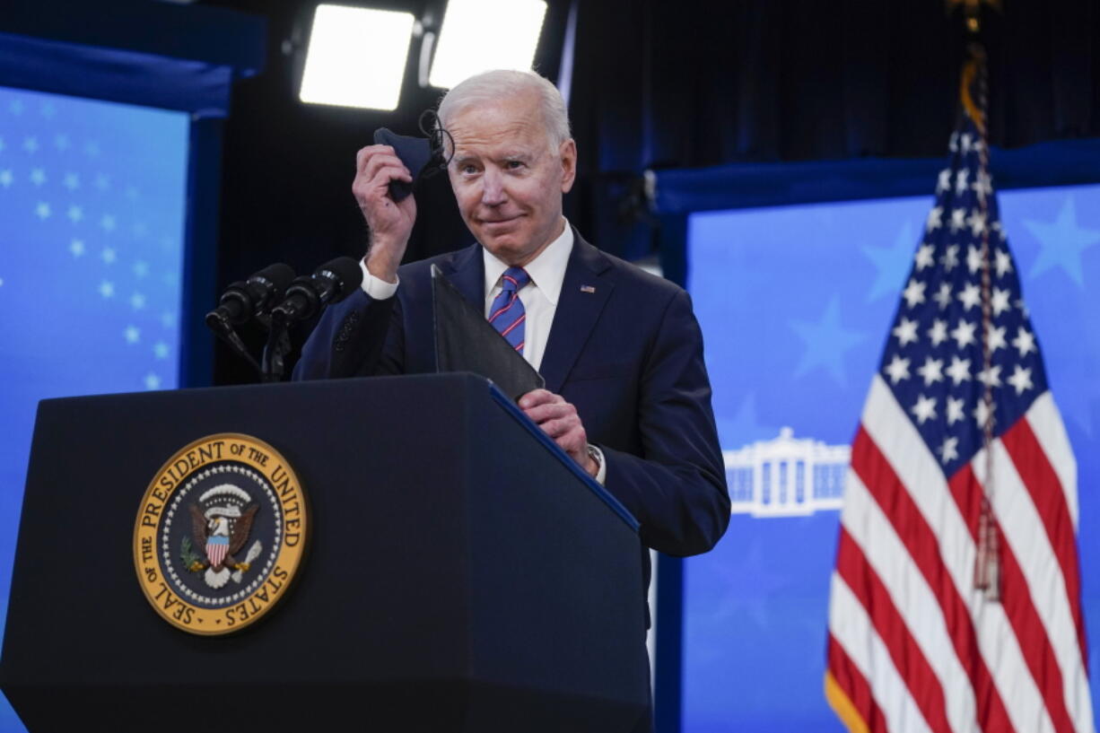 President Joe Biden holds a face mask as he speaks during an event to mark Equal Pay Day in the South Court Auditorium in the Eisenhower Executive Office Building on the White House Campus Wednesday, March 24, 2021, in Washington.