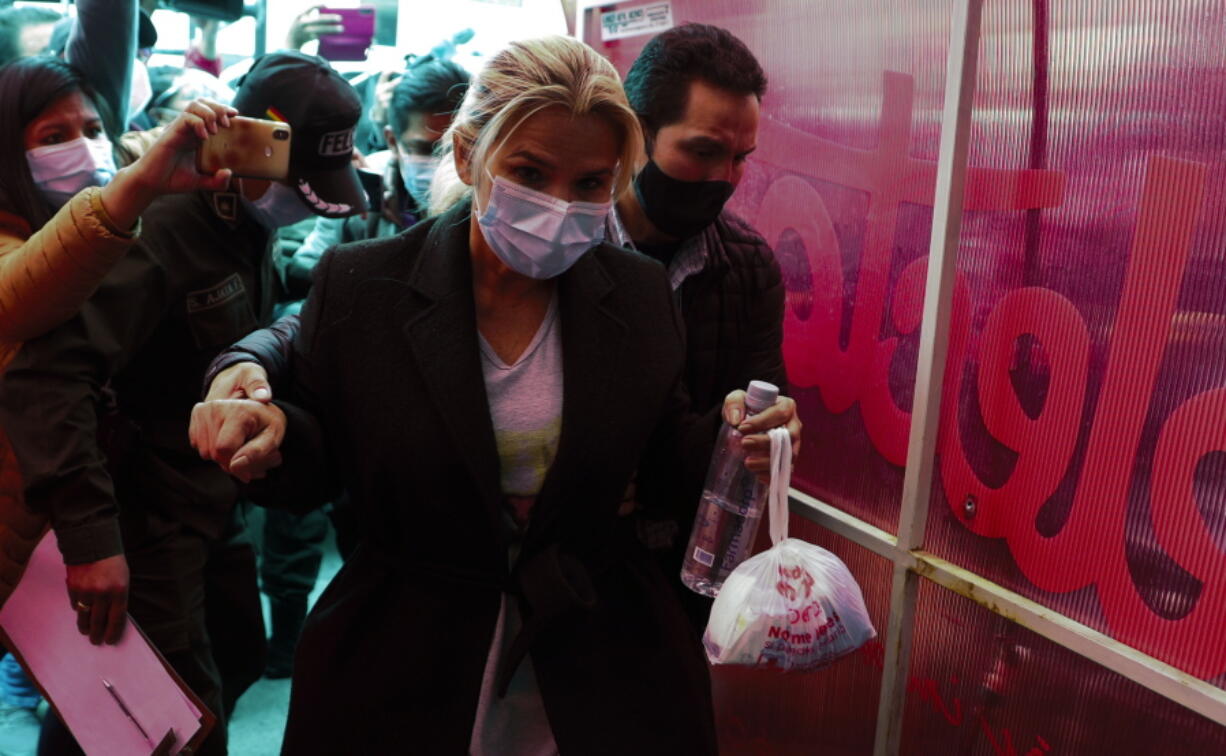 Bolivia&#039;s former interim President Jeanine Anez is escorted into a police station after giving her statement at the prosectors&#039;s office, in La Paz, Bolivia, Saturday, March 13, 2021. The conservative interim president who led Bolivia for a year was arrested Saturday as officials of the restored leftist government pursue those involved in the 2019 ouster of socialist leader Evo Morales, which they regard as a coup, and the administration that followed.