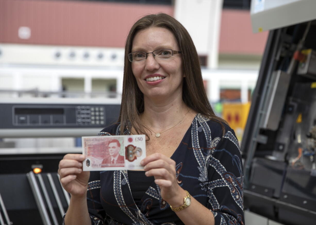 In this photo provided by the Bank of England on Thursday, March 25, 2021,S arah John, Chief Cashier at the Bank of England, holds the new 50-pound note featuring scientist Alan Turing. The rainbow flag is flying proudly above the Bank of England in the heart of London&#039;s financial district to commemorate legendary World War II codebreaker Alan Turing, the new face of Britain&#039;s 50-pound note. The design of the banknote, which is the most valuable in circulation, was unveiled Thursday before it is formally issued on June 23, Turing&#039;s birthday.