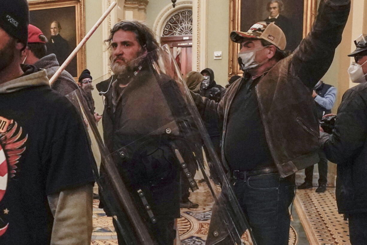 In this Jan. 6, 2021, photo, rioters, including Dominic Pezzola, center with police shield, are confronted by U.S. Capitol Police officers outside the Senate Chamber inside the Capitol, Wednesday, Jan. 6, 2021, in Washington. The Proud Boys and Oath Keepers make up a fraction of the more than 300 Trump supporters charged so far in the siege that led to Trump&#039;s second impeachment and resulted in the deaths of five people, including a police officer. But several of their leaders, members and associates have become the central targets of the Justice Department&#039;s sprawling investigation.