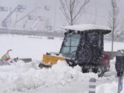 A maintenance worker uses a plow as a snowstorm rips across the intermountain West Sunday, March 14, 2021, in Denver. Forecasters are calling for the storm to leave at least another six inches of snow during the day before moving out on to the eastern plains.