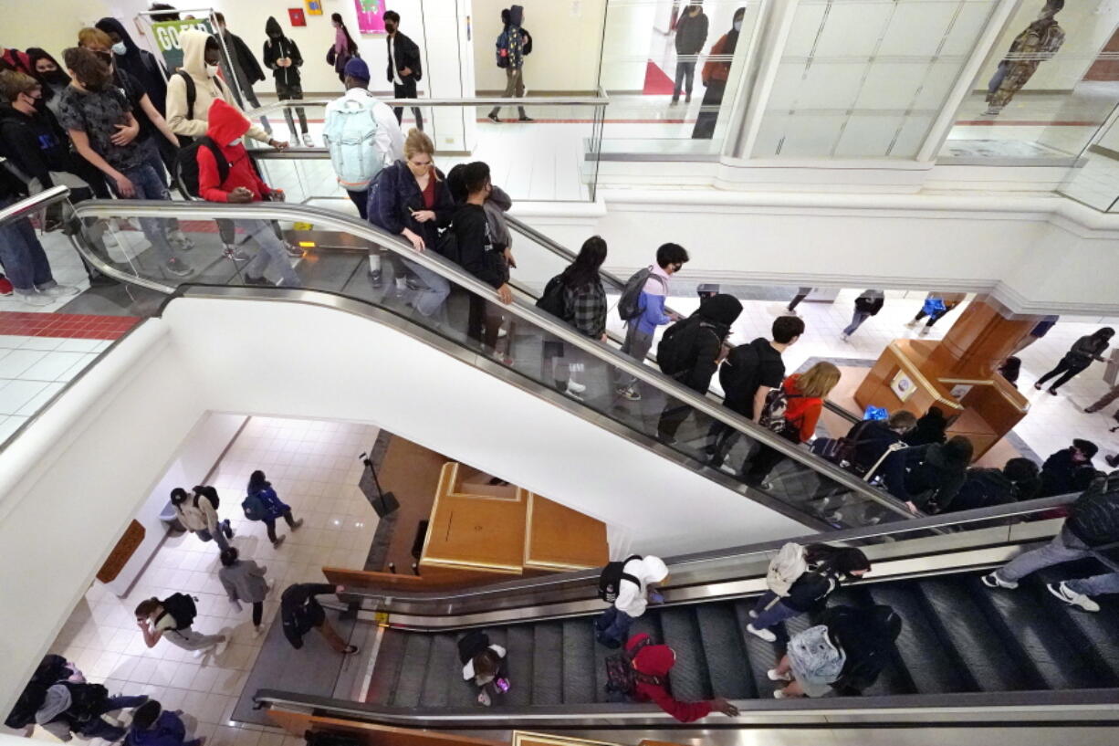 Students commute between classes at Downtown Burlington High School, Monday, March 22, 2021, in Burlington, Vt. Students who once shopped at a downtown mall are now attending high school in the mall&#039;s former Macy&#039;s department store, taking escalators to and from classes. The existing Burlington High School was closed last August after PCBs were found in the building.