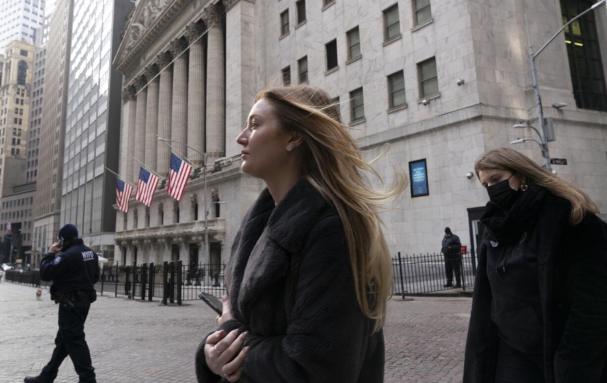 FILE - In this Wednesday, Jan. 13, 2021 file photo, people walk by the New York Stock Exchange.  Stocks are off to a mixed start on Wall Street as another sharp rise in bond yields unsettled investors. Technology stocks were among the biggest losers in the early going Friday, March 121 pulling the Nasdaq down 1.5% while the broader S&amp;P 500 index gave back 0.5%.