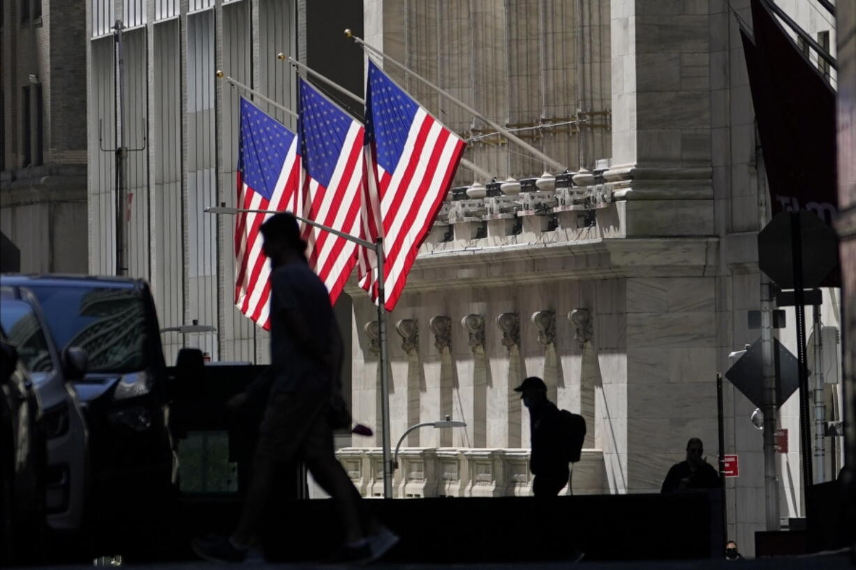 FILE - In this Oct. 14, 2020 file photo, pedestrians pass the New York Stock Exchange in New York.  Shares are opening mostly lower on Wall Street, Wednesday, March 17, 2021,  as investors cautiously await the U.S. central bank&#039;s latest assessment on the economy.