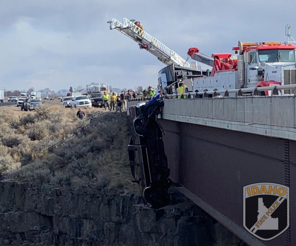 This image provided by the Idaho State Police shows the scene where authorities say a set of camp trailer safety chains and quick, careful work by emergency crews saved two people after their pickup truck plunged off a bridge, leaving them dangling above a deep gorge in southern Idaho on Monday, March 15, 2021.