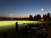 Fans sit on the berm north of the football field at Hudson's Bay High School on Friday. The Eagles beat R.A. Long 28-13 in the first varsity game on campus at the school, which was built in 1955.