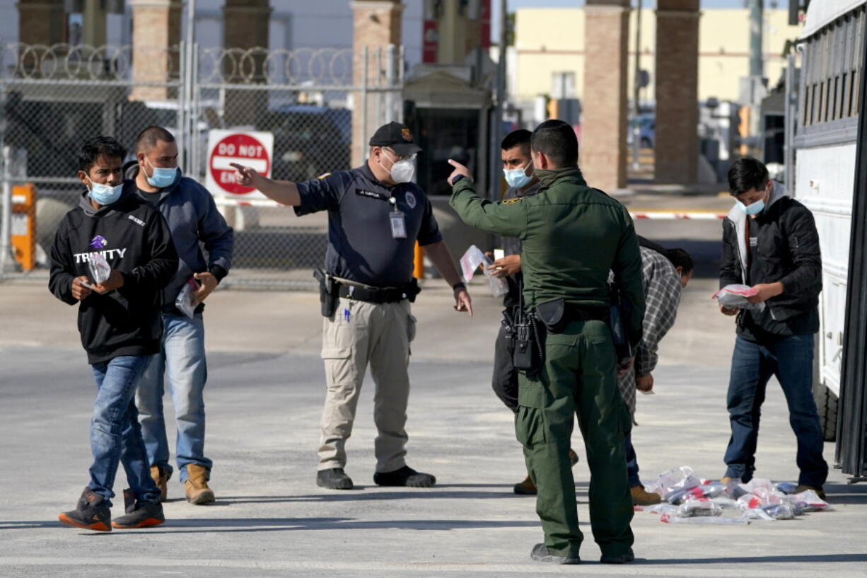 U.S. Customs and Border Protection officers, center, instruct migrants to walk toward the McAllen-Hidalgo International Bridge while deporting them to Mexico, Saturday, March 20, 2021, in Hidalgo, Texas. The fate of thousands of migrant families who have recently arrived at the Mexico border is being decided by a mysterious new system under President Joe Biden. U.S. authorities are releasing migrants with &quot;acute vulnerabilities&quot; and allowing them to pursue asylum. But it&#039;s not clear why some are considered vulnerable and not others.