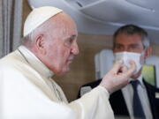 Pope Francis speaks to journalists, Monday, March 8, 2021, while flying back to The Vatican at the end of his four-day trip to Iraq where he met with different Christian communities and Shiite revered cleric Grand Ayatollah Ali al-Sistani. At right pope&#039;s spokesperson Matteo Bruni.